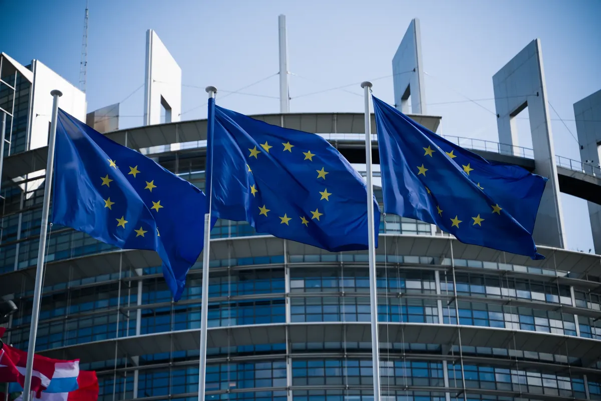 European Union flags waving outside the European Parliament in Strasbourg.
